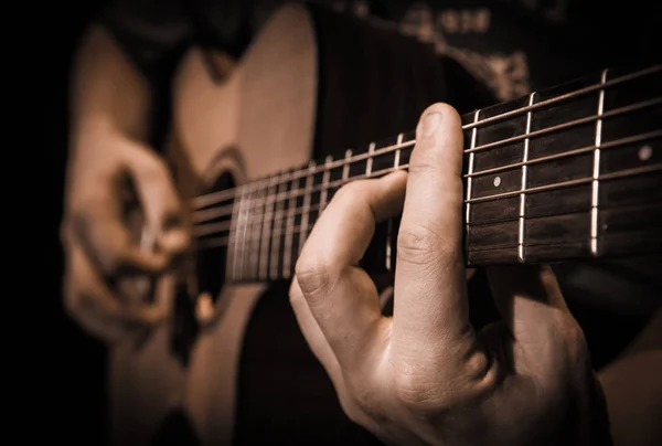 Feche as mãos nas cordas de uma guitarra — Fotografia de Stock