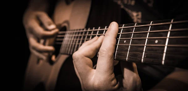 Feche as mãos nas cordas de uma guitarra — Fotografia de Stock