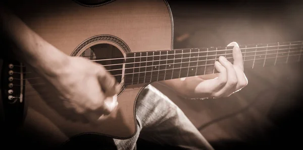 Feche as mãos nas cordas de uma guitarra — Fotografia de Stock