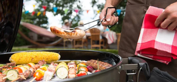 Gezin dat een partij in hun tuin barbecue — Stockfoto