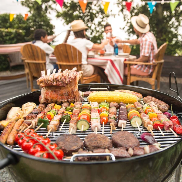 Gezin dat een partij in hun tuin barbecue — Stockfoto