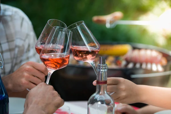 Amigos felizes se divertindo ao ar livre, mãos torrando copo de vinho rosa — Fotografia de Stock