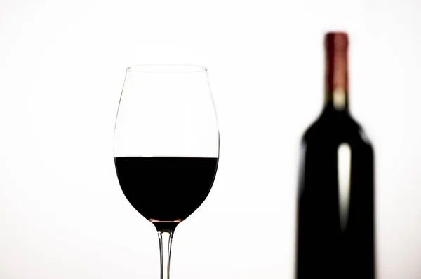 Bouteille de vin rouge et verre sur fond blanc — Photo