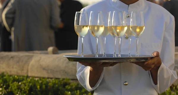 Professionele mannelijke ober in uniform serveren champagne — Stockfoto