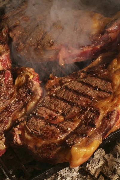 Tjock ribeye stek brände sällsynt på en gjutjärn grill — Stockfoto