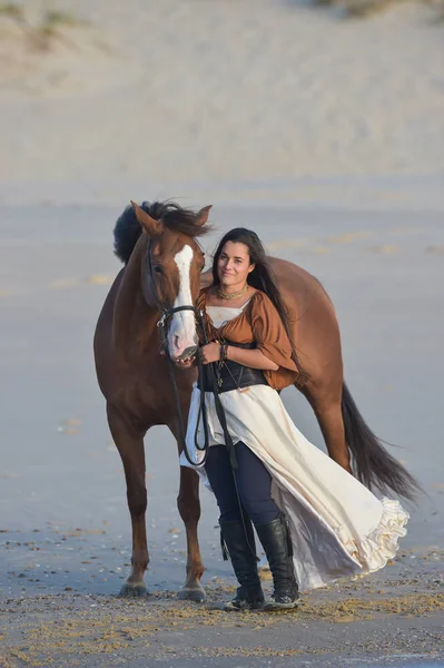 Jovem senhora montando um cavalo na praia no início da manhã — Fotografia de Stock