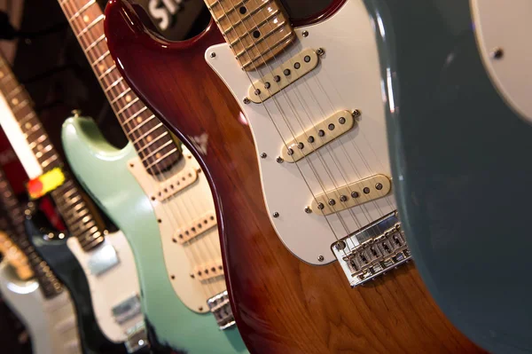 Muchas guitarras eléctricas colgando en la pared en la tienda —  Fotos de Stock