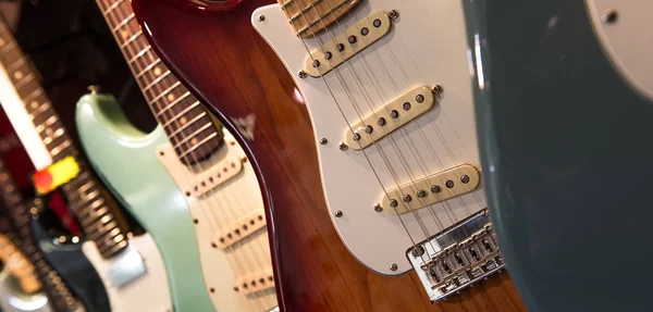 Muchas guitarras eléctricas colgando en la pared en la tienda — Foto de Stock