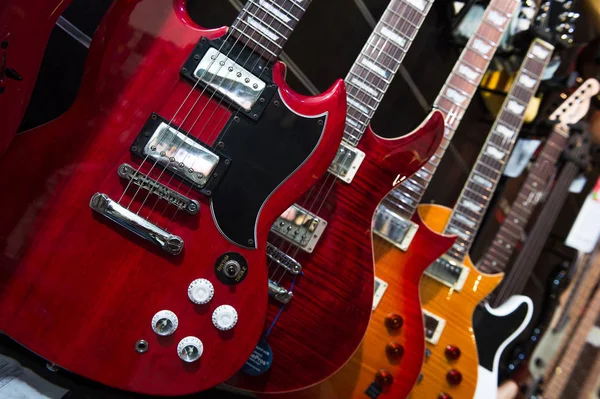Muchas guitarras eléctricas colgando en la pared en la tienda — Foto de Stock