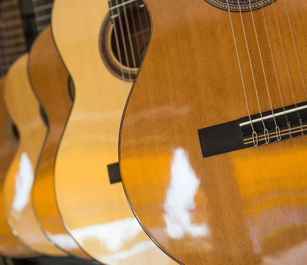 Muchas guitarras clásicas colgando de la pared en la tienda —  Fotos de Stock