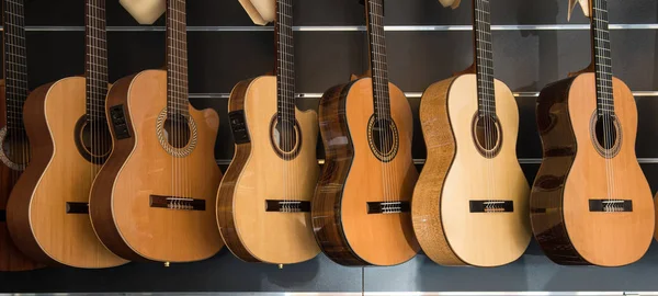 Vele klassieke gitaren opknoping op een muur in de winkel — Stockfoto