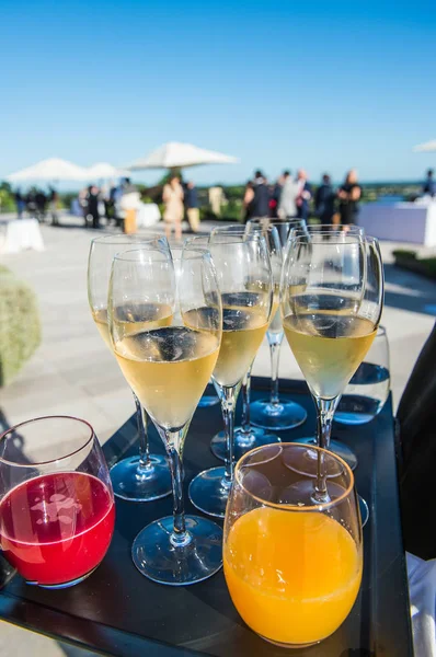 Ober champagne en fruit sap serveren op een dienblad — Stockfoto