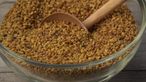 Wooden spoon in a big bowl of pollen — Stock Video