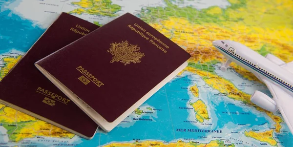 Francouzské pasy na pozadí mapy a letadlo — Stock fotografie