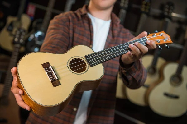 Adolescente feliz elegir mejor guitarra acústica en tienda musical — Foto de Stock
