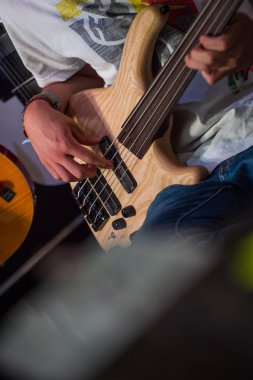 Dükkanda bir bas gitar çalmaya müzisyen