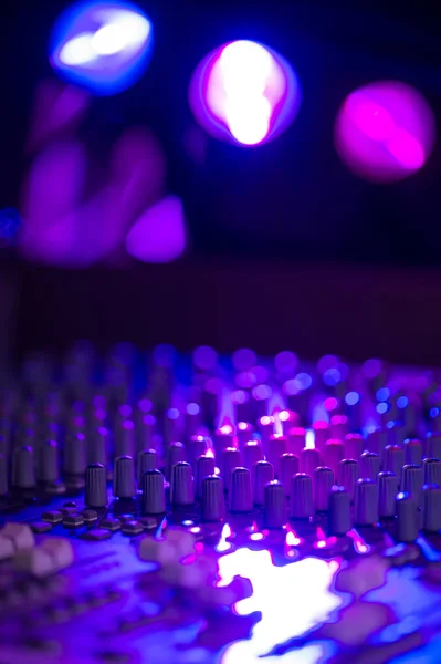 Panneau de commande de mélangeur de musique sonore sur la lumière colorée — Photo