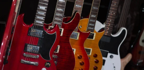 Muchas guitarras eléctricas colgando en la pared en la tienda —  Fotos de Stock