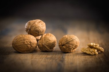 Ceviz taneleri ve rustik eski meşe masada bütün ceviz