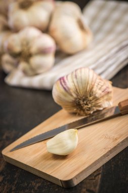 Antika ahşap arka plan üzerinde karanfil ve sarımsak ampul sarımsak