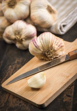 Antika ahşap arka plan üzerinde karanfil ve sarımsak ampul sarımsak