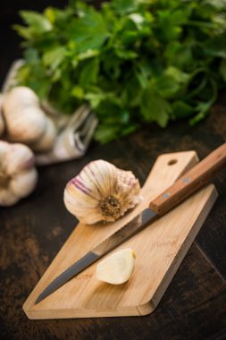 Antika ahşap arka plan üzerinde karanfil ve sarımsak ampul sarımsak