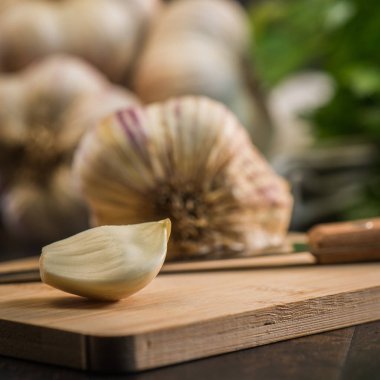 Antika ahşap arka plan üzerinde karanfil ve sarımsak ampul sarımsak