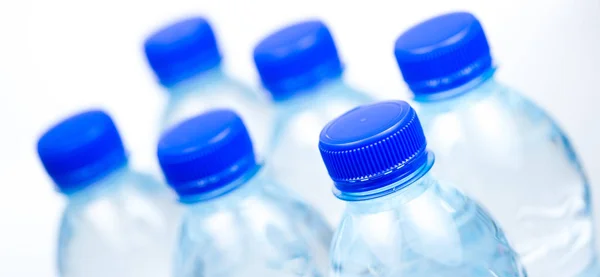 Plastikflaschen mit Wasser isoliert auf weißem Hintergrund — Stockfoto