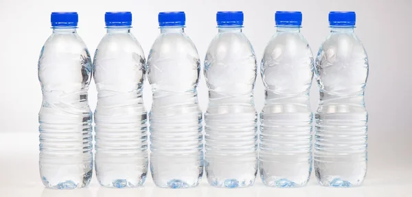 Plastikflaschen mit Wasser isoliert auf weißem Hintergrund — Stockfoto