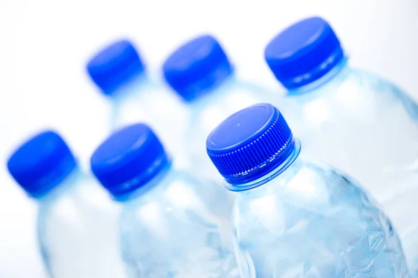 Plastikflaschen mit Wasser isoliert auf weißem Hintergrund — Stockfoto