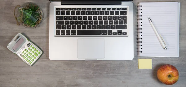 Mesa de escritório de madeira com laptop e suprimentos — Fotografia de Stock