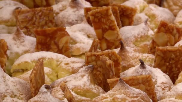 Cream puffs filled vanilla custard and dusted with icing on a plat and nougatine — Stock Video