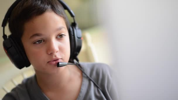 Niño jugando en el ordenador con auriculares — Vídeos de Stock