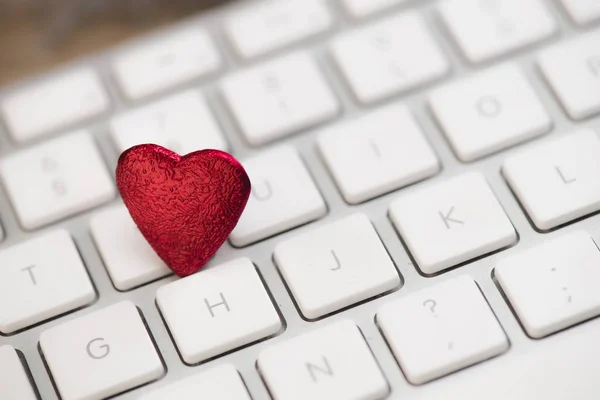 Small red heart on keyboard internet dating concept