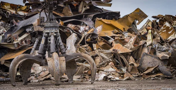 Grote bijgehouden graafmachine werken een stalen stapel op een metalen recycle — Stockfoto