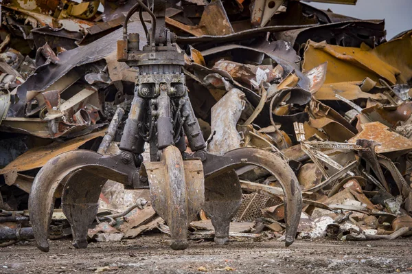 Grote bijgehouden graafmachine werken een stalen stapel op een metalen recycle — Stockfoto