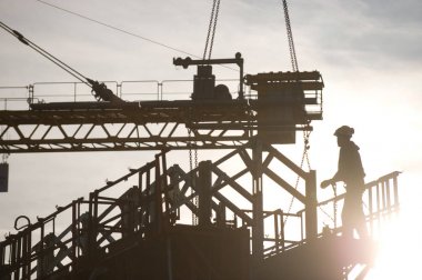 Silhouette of construction worker on construction site, France clipart