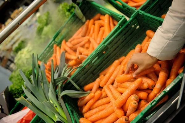 Mujer compra zanahoria y comida en el supermercado — Foto de Stock