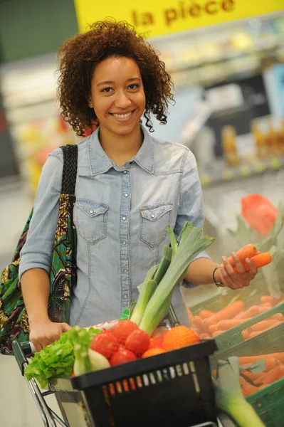 Frau kauft Gemüse und Lebensmittel im Supermarkt — Stockfoto