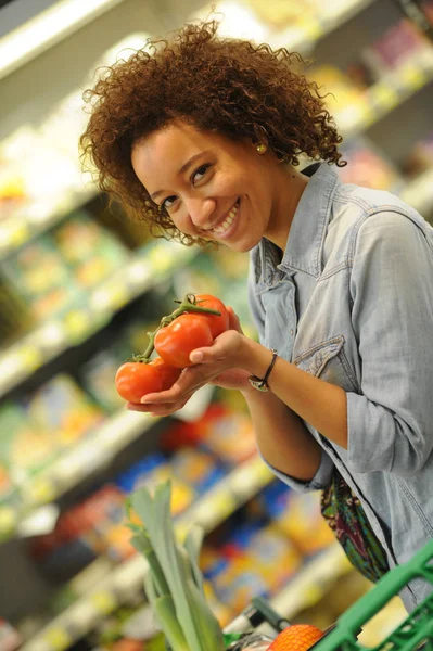 Mujer compra verduras y alimentos en el supermercado —  Fotos de Stock