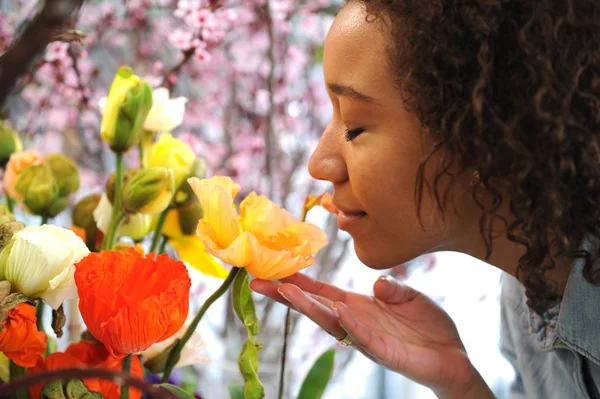 Consumismo: Mujer oliendo flores frescas . — Foto de Stock