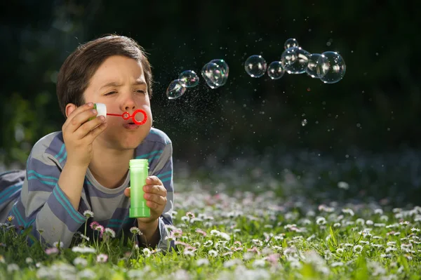 Niño jugando a soplar burbujas de jabón — Foto de Stock