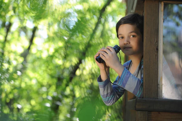 Barn observerar naturen med ett par kikare på fönster o — Stockfoto