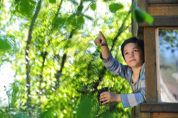 Barn observerar naturen med ett par kikare på fönster o — Stockfoto