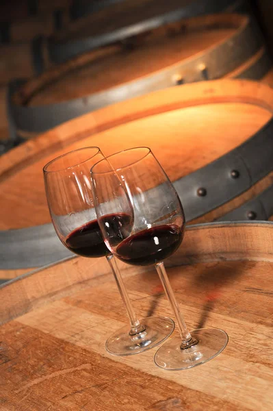 Two glass of red wine and old barrel in cellar — Stock Photo, Image