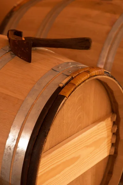 Un maillet reposant sur des tonneaux de vin vintage à l'intérieur d'une cave à vin — Photo