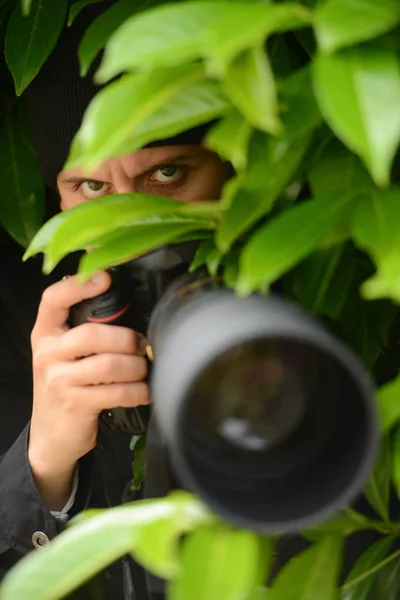 Paparazzi, mladá a atraktivní muž fotografování se svým fotoaparátem dslr — Stock fotografie