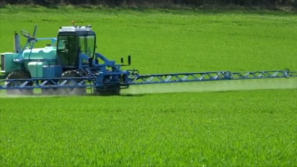 Agriculture fertilizer working on farming field, agriculture machinery working on cultivated field and spraying pesticide — Stock Video