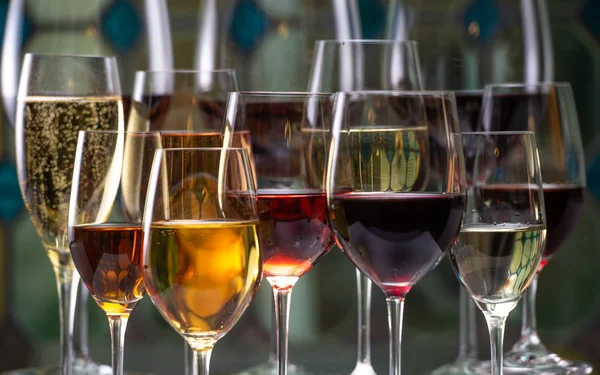 Champagne, blanc, rose et rouge gagne et boit dans des verres sur fond de vitrail — Photo