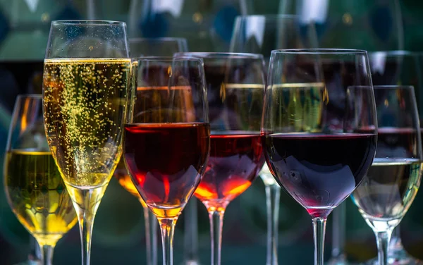 Szampan, biały, różowe i czerwone wygrywa i napoje w szklankach na tle witrażu — Zdjęcie stockowe